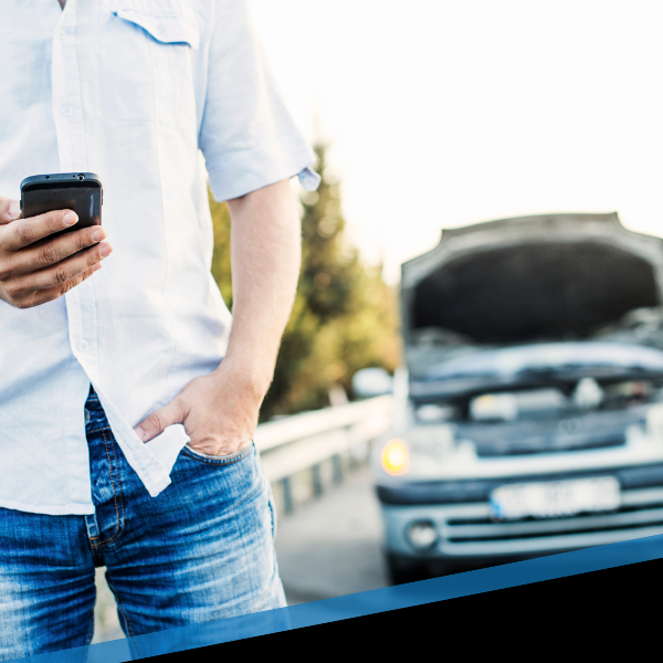 man with a broken down car calling for roadside assistance